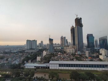 Buildings in city against sky during sunset