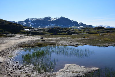 Scenic view of lake and mountains against clear sky