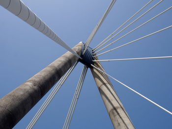 A close up of the supports and cables of the suspension bridge in southport against a blue sky