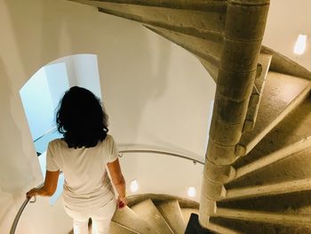Rear view of woman on spiral staircase