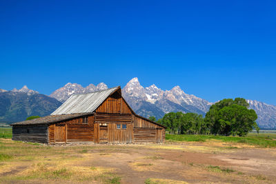 Built structure on field against clear blue sky