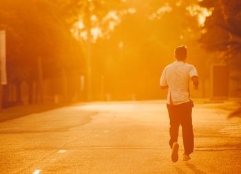 Rear view of a man standing on road