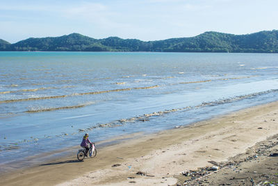 Man riding bicycle on beach