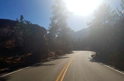 Road amidst trees against sky