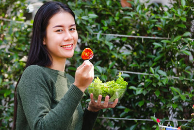 Portrait of a young woman holding fruits