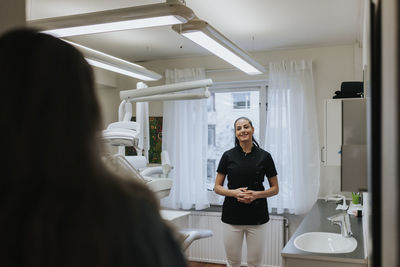 Female dentist standing in office