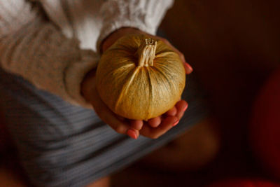 Close-up of hand holding pumpkin