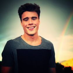 Portrait of smiling young man standing against sky
