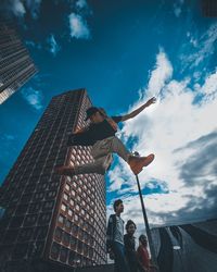 Low angle view of people standing against sky