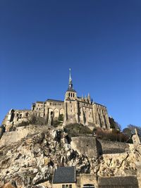 Low angle view of historical building against clear blue sky