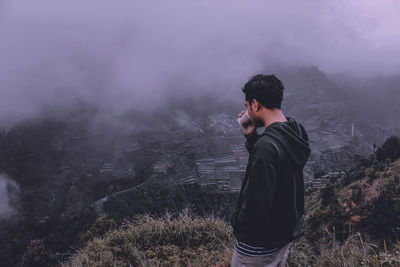 Side view of young man standing on land