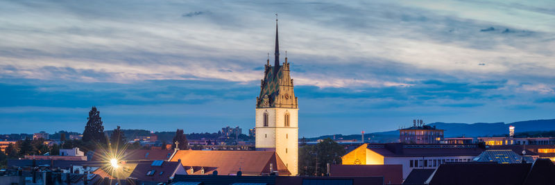 View of illuminated buildings against cloudy sky