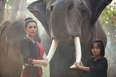 Portrait of woman standing against wall in zoo