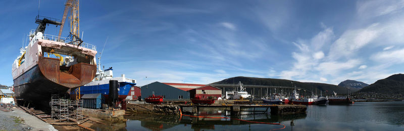 Boats moored at harbor against sky