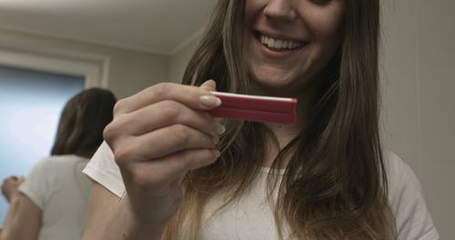 Portrait of smiling woman holding camera