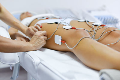 Midsection of woman lying on bed