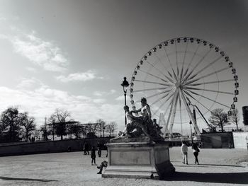 Low angle view of sculptures and roue de paris against sky