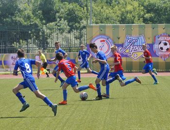 Group of people playing soccer on field