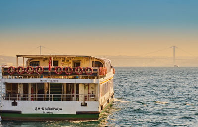 Ship in sea against sky during sunset