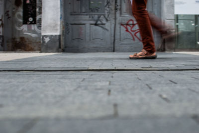 Blurred motion of man walking on footpath