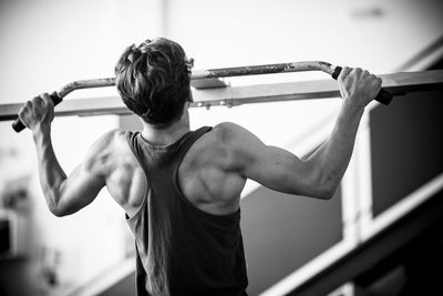 Rear view of man exercising at gym