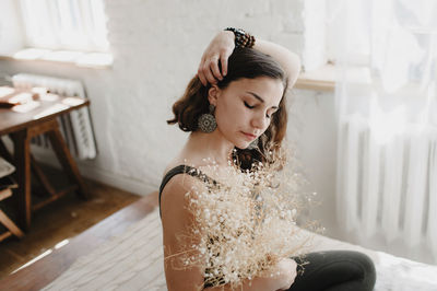 Midsection of woman sitting in white dress