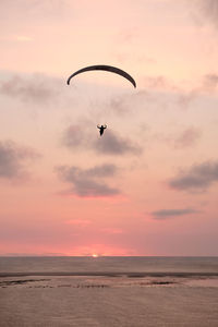 Silhouette of kite flying against sky during sunset