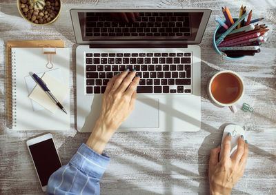 Cropped hands of businesswoman working at desk in office