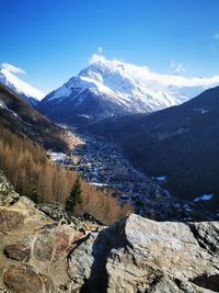 Scenic view of snowcapped mountains against blue sky