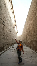 Full length of woman standing amidst wall