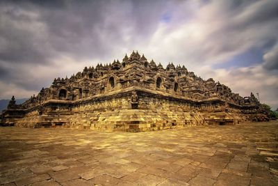 Old temple building against cloudy sky