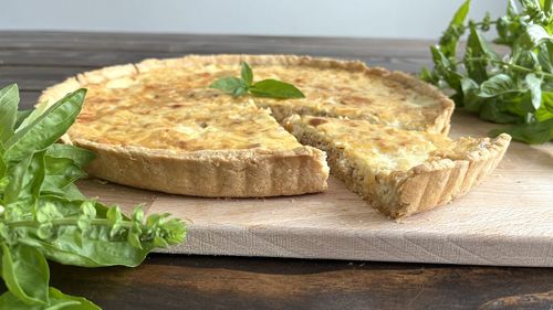 Quiche on table with slice, close up