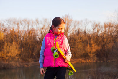 Full length of woman standing against pink water