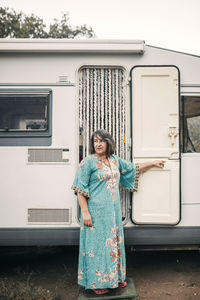 Mature woman standing in front of motor home