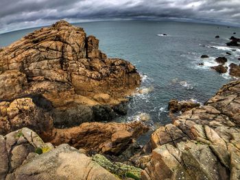 Scenic view of rocks on beach against sky