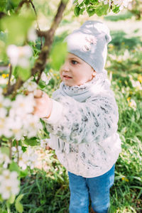 Portrait of young woman standing against plants