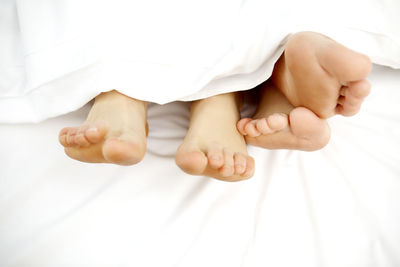 Low section of baby feet on bed