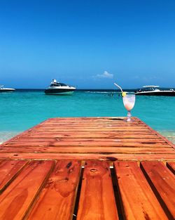 View of drink on wooden pier