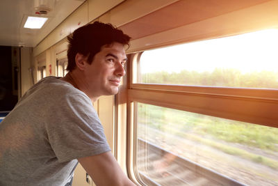 Man travels alone by train and looks out
