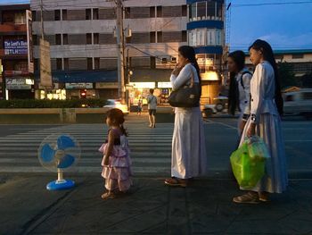 Full length of child walking on sidewalk at night