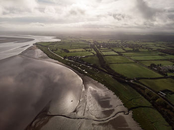 Aerial view of river amidst field against sky