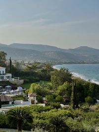 Scenic view of town by sea against sky