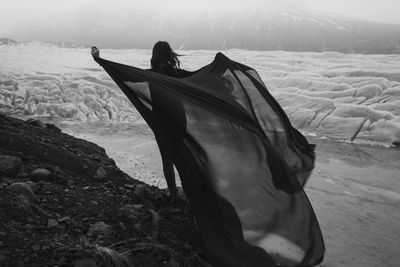 Graceful lady with waving fabric sheet monochrome scenic photography