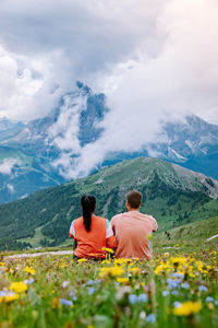 Rear view of men on mountain against sky