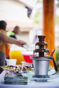 Chocolate fountain on table against people