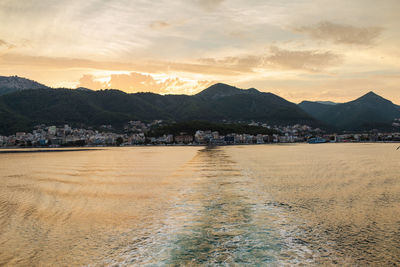 Scenic view of sea and buildings against sky during sunset