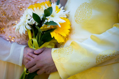 Midsection of woman holding flower bouquet