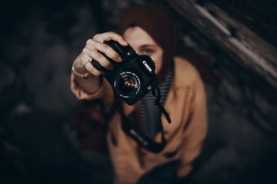 Portrait of young woman holding camera