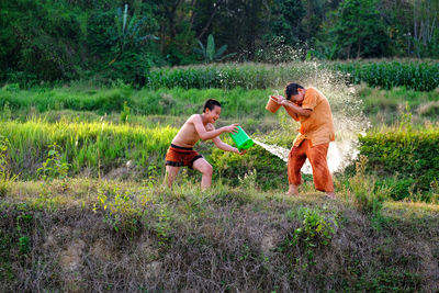 Boys enjoying with water on field