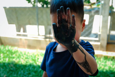 Close-up of boy with dirty hand
